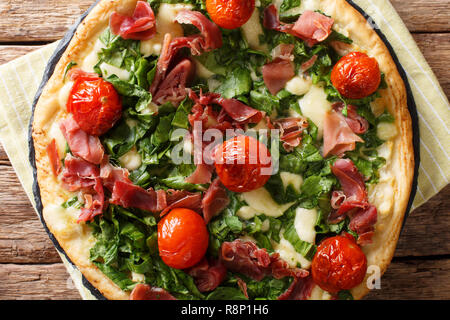 Pizza mit Spinat, Tomaten, Schinken und Käse close-up auf dem Tisch. horizontal oben Ansicht von oben Stockfoto