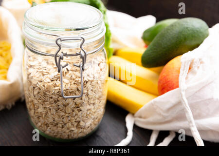 Null Abfall einkaufen. Paket-freie Lebensmittel auf dunklen Holztisch mit Textur. Frisches Obst und Gemüse im Eco Baumwolle Taschen. Kunststoff-Paket Stockfoto