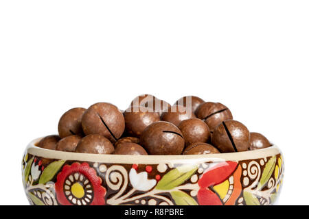 Frische organische geschält Macadamianüsse in Keramik Schüssel isoliert auf Weiss. Stockfoto