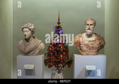 Weihnachtsbaum zwischen Marmorbüsten der Römische Kaiser Marcus Aurelius (L) und dem römischen Feldherrn Tiberius Claudius Pompeianus (R) im Nationalen Archäologischen Museum (Museo Archeologico Nazionale di Venezia) in Venedig, Italien installiert. Stockfoto