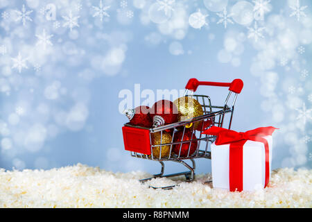 Warenkorb mit Weihnachten Kugeln auf Schnee. Weihnachten Verkauf. Stockfoto