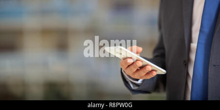 Mann mit Handy. Junge Unternehmer in der Wirtschaft tragen, die ein Mobiltelefon, Detailansicht auf dem Smartphone, Banner, kopieren Raum Stockfoto