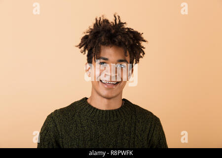 Portrait eines glücklichen jungen afrikanischen Mann in Pullover über beigen Hintergrund isoliert gekleidet Stockfoto