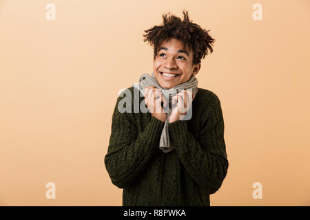 Portrait eines glücklichen jungen afrikanischen Mann im Herbst Kleidung über beigen Hintergrund isoliert gekleidet, Weg suchen Stockfoto