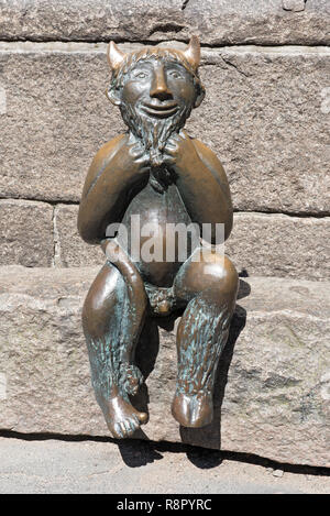 Kleine Teufel sitzt auf einem Stein vor der Marienkirche (St. Marys Kirche) in Lübeck, Deutschland Stockfoto