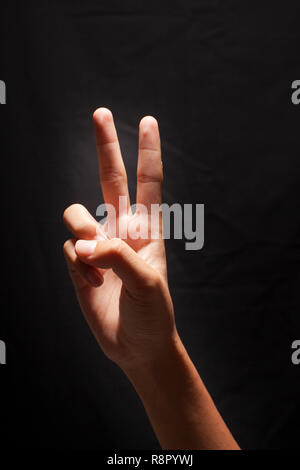Zwei Finger, Zeigefinger und Mittelfinger. Hand Sieg auf schwarzen Hintergrund isoliert. Symbol Konzept mit Hand Finger. Stockfoto