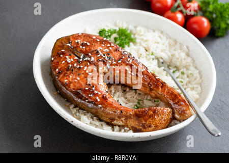 Gegrilltes Lachssteak mit Teriyaki-sauce und weißer Reis auf einen Teller. Leckeres Abendessen Stockfoto