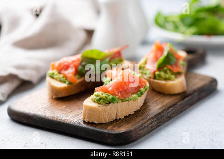 Avocado und Räucherlachs auf Brot. Köstliche Vorspeise, Snack, Fingerfood Stockfoto