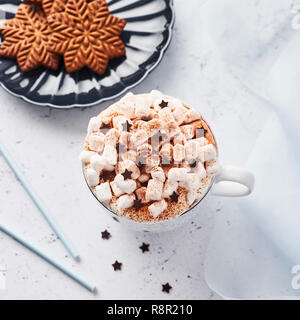 Heiße Schokolade oder Kakao mit Schlagsahne und Marshmallow candy bestreut mit Zimt oder Kakao Pulver mit Schokolade Sterne und Weihnachten Lebkuchen Stockfoto