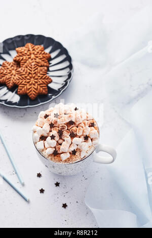 Heiße Schokolade oder Kakao mit Schlagsahne und Marshmallow candy bestreut mit Zimt oder Kakao Pulver mit Schokolade Sterne und Weihnachten Lebkuchen Stockfoto
