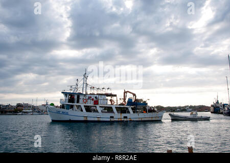 Nea Moudania, Chalkidiki Halbinsel, Griechenland, August 12,2018: Fischerboot kommt am Hafen von Nea Moudania, früh im bewölkten Morgen nach der Nacht angeln Stockfoto