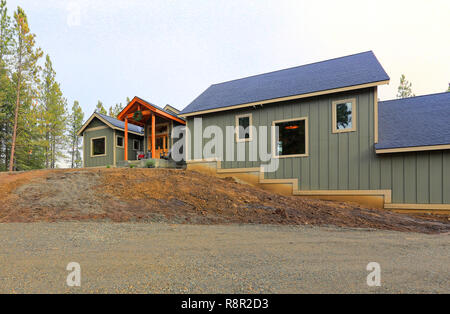 Neues graues Holz Landhaus Fassade mit blauer Himmel und grünes Gras. Stockfoto