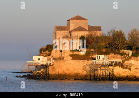 Frankreich, Charente Maritime, Saintonge, Mündung der Gironde, Saintonge, Talmont sur Gironde, Les Plus beaux villages de France (Schönste Dörfer Frankreichs), Hütten auf Stelzen für Carrelet (Fisherman's Hut) Fischernetz und Sainte Radegonde Kirche, in der Saintonge im romanischen Stil des 12. Jahrhunderts Stockfoto