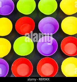 Blick von oben auf die vielen leeren multicolor Silikonformen für Cupcakes auf Backblech Stockfoto