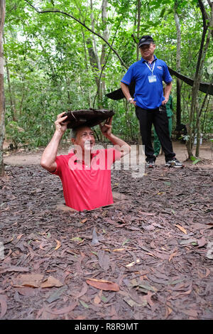 Cu Chi Tunnel Vietnam - ein Tourist betritt 2018 einen verborgenen Tunnel in Chu Chi in Vietnam Stockfoto