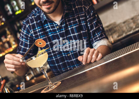 Junge Barkeeper stehen an der Theke, Kreis von Orange auf Glas lächelnd glücklich close-up Stockfoto