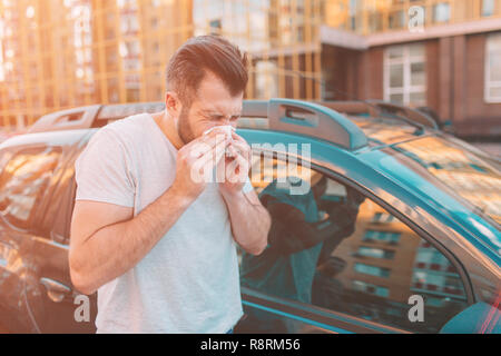 Bild von einem bärtigen Mann mit Taschentuch. Kranken Kerl hat Schnupfen. Man macht eine Heilung für die allgemeine Kälte Stockfoto