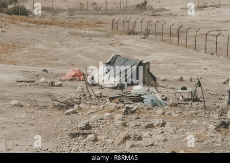 Häuser der Beduinen in der Wüste in der Nähe des Toten Meeres. Den armen Regionen der Welt. Eine bedürftige Beduinen sitzen am Zelt. Armut in Jordanien. Naher Osten Stockfoto