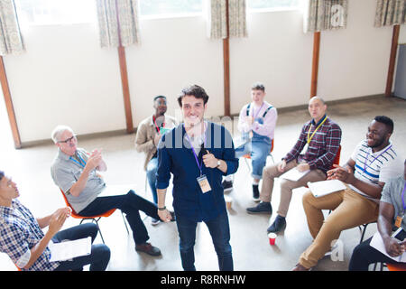 Männer klatschen für Lautsprecher in der Gruppe Therapie Stockfoto