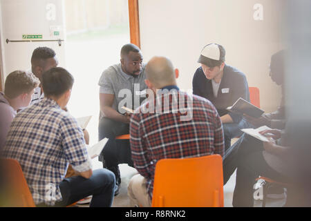 Männer lesen und diskutieren Bibel im Kreis im Gebet Gruppe Stockfoto