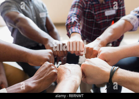 Männer verbinden Fäuste im Kreis in der Gruppe Therapie Stockfoto