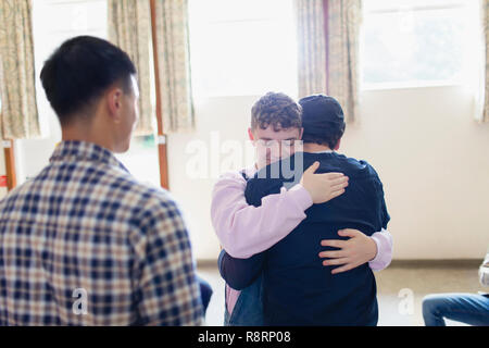 Männer umarmen in Gruppe Therapie Stockfoto