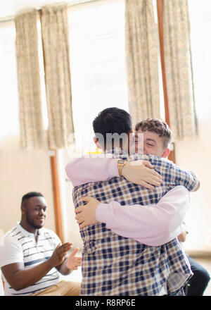 Männer umarmen in Gruppe Therapie Stockfoto