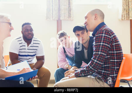 Aufmerksame Männer Reden und Zuhören in der Gruppe Therapie Stockfoto