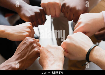 Männer verbinden Fäuste in Kreis Stockfoto