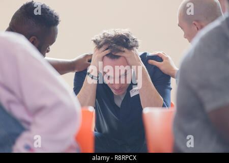 Männer tröstlich umgekippt Mann in der Gruppe Therapie Stockfoto