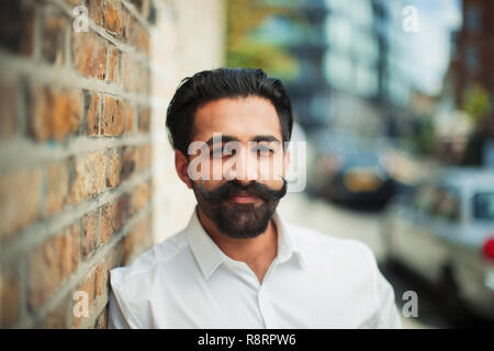 Portrait selbstbewussten jungen Mann mit Schnurrbart auf städtischen Gehsteig Lenkstange Stockfoto