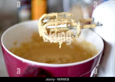 Kuchenteig Mix in der Schüssel und an Hand Mixer Stockfoto