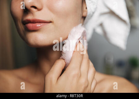 Schöne junge Frau in Badetuch am Bad eingewickelt, mit Powder Puff Stockfoto