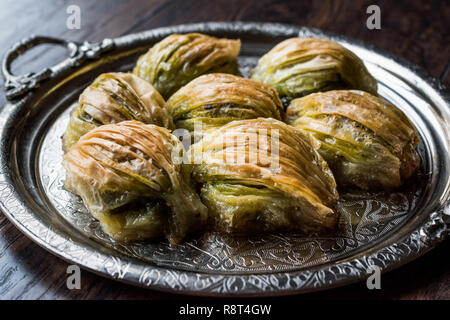 Türkische Midye Baklava (Muschel Form Baklawa) mit grünen Pistazien und Butter Creme in Silber Fach. Dessert mit Pistazien Stockfoto
