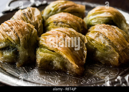 Türkische Midye Baklava (Muschel Form Baklawa) mit grünen Pistazien und Butter Creme in Silber Fach. Dessert mit Pistazien Stockfoto