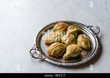 Türkische Midye Baklava (Muschel Form Baklawa) mit grünen Pistazien und Butter Creme in Silber Fach. Dessert mit Pistazien Stockfoto