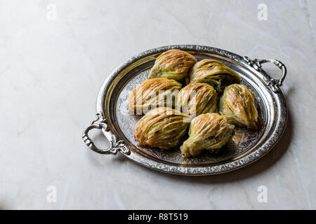 Türkische Midye Baklava (Muschel Form Baklawa) mit grünen Pistazien und Butter Creme in Silber Fach. Dessert mit Pistazien Stockfoto