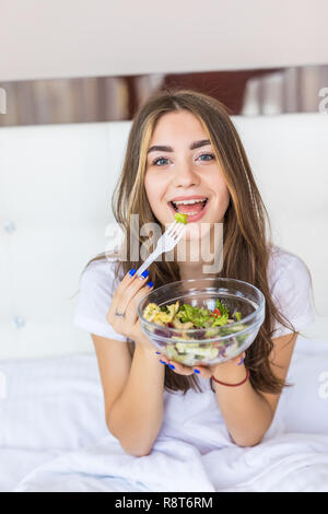 Portrait von Glücklich lächelnde Frau eine gesunde Frühstück im Bett. Stockfoto