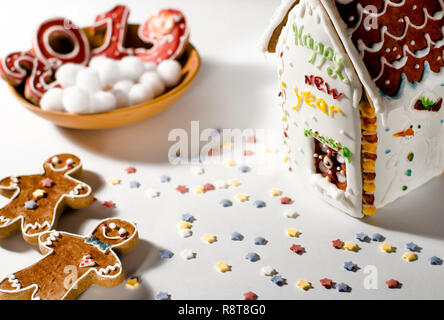 Weihnachtskarte: auf einer Holzplatte Es gibt rote Ingwer Cookies in der Form von Zahlen 2019 und Weiße runde Schneeflocken, neben dem Lügen Lebkuchen Stockfoto