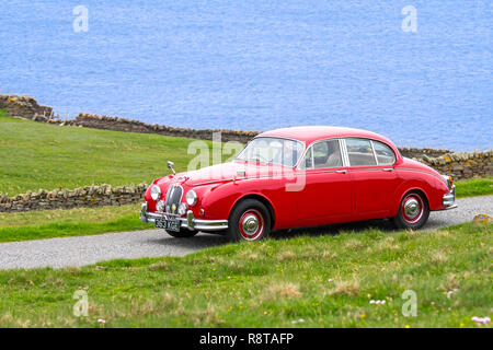 Rot 1962 Jaguar Mk 2/Jaguar Mk II 3,8 Liter klassische Sportwagen entlang der Küstenstraße fahren Stockfoto