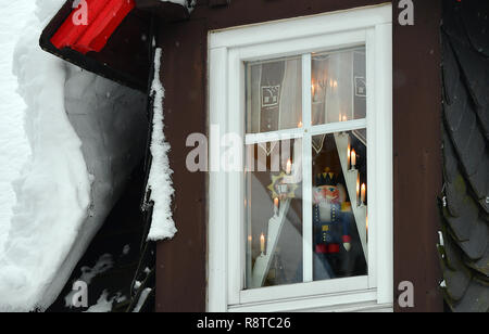 Seiffen, Deutschland. 15 Dez, 2018. Ein Nussknacker steht hinter einem schneebedeckten Dach Fenster in der Toy Dorf Seiffen. In der Adventszeit Seiffen ist ein Touristenmagnet und zieht zahlreiche Touristen aus dem In- und Ausland. Credit: Hendrik Schmidt/dpa-Zentralbild/ZB/dpa/Alamy leben Nachrichten Stockfoto