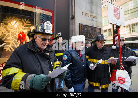 Chicago, USA. 17. Dezember 2018. Chicago Feuerwehrmänner, außerhalb Macy's Flagship Store an der alten Marshall Fields Gebäude an der State Street, singen Weihnachtslieder, Geld für die lokale Heilsarmee Liebe zu erhöhen. Credit: Stephen Chung/Alamy leben Nachrichten Stockfoto