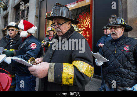 Chicago, USA. 17. Dezember 2018. Chicago Feuerwehrmänner, außerhalb Macy's Flagship Store an der alten Marshall Fields Gebäude an der State Street, singen Weihnachtslieder, Geld für die lokale Heilsarmee Liebe zu erhöhen. Credit: Stephen Chung/Alamy leben Nachrichten Stockfoto