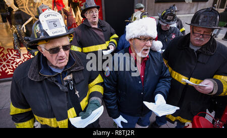 Chicago, USA. 17. Dezember 2018. Chicago Feuerwehrmänner, außerhalb Macy's Flagship Store an der alten Marshall Fields Gebäude an der State Street, singen Weihnachtslieder, Geld für die lokale Heilsarmee Liebe zu erhöhen. Credit: Stephen Chung/Alamy leben Nachrichten Stockfoto