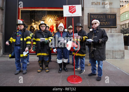 Chicago, USA. 17. Dezember 2018. Chicago Feuerwehrmänner, außerhalb Macy's Flagship Store an der alten Marshall Fields Gebäude an der State Street, singen Weihnachtslieder, Geld für die lokale Heilsarmee Liebe zu erhöhen. Credit: Stephen Chung/Alamy leben Nachrichten Stockfoto