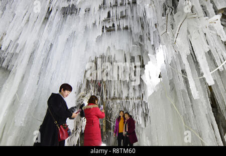 Linxia, Gansu Provinz Chinas. 16 Dez, 2018. Touristen nehmen Fotos vor eiszapfen an Dadunxia scenic Spot in Linxia Hui Autonomen Präfektur im Nordwesten der chinesischen Provinz Gansu, Dez. 16, 2018. Credit: Shi Youdong/Xinhua/Alamy leben Nachrichten Stockfoto