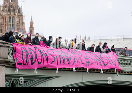 London, Großbritannien. 18. Dezember, 2018. Aktivisten aus der ganzen Vereinigten Königreich von Jonathan Bartley, Co - Führer der Grünen Partei begleitet, drop ein Banner von Westminster Bridge in Solidarität mit der Stansted 15 und alle Migranten auf den Internationalen Tag der Migranten. Der Stansted 15 wurden am 10. Dezember von Anti überführt - Terrorismus Handlung unter der Luftfahrt und Maritime Security Act 1990 folgenden gewaltfreie direkte Aktionen, um zu versuchen, ein Home Office Abschiebung Flug prekären Migrantinnen zu Nigeria, Ghana und Sierra Leone aus weg von Stansted Airport im März 2017 zu verhindern. Credit: Mark Kerrison/ Stockfoto