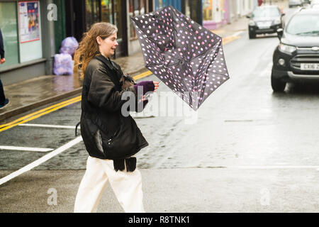 Aberystwyth Wales UK, Dienstag, 18. Dezember 2018 Großbritannien Wetter: eine Frau kämpft mit ihrem Schirm auf einem nassen und windigen Tag in Aberystwyth Wales, mit dem Met Office eine 'gelbe' Warnung für Heavy Rain und die Gefahr von störenden Überschwemmungen und schlechte Voraussetzungen für die meisten von Wales und Südwestengland Photo Credit: Keith Morris/Alamy leben Nachrichten Stockfoto