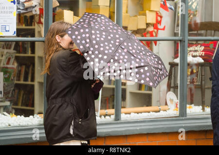 Aberystwyth Wales UK, Dienstag, 18. Dezember 2018 Großbritannien Wetter: eine Frau kämpft mit ihrem Schirm auf einem nassen und windigen Tag in Aberystwyth Wales, mit dem Met Office eine 'gelbe' Warnung für Heavy Rain und die Gefahr von störenden Überschwemmungen und schlechte Voraussetzungen für die meisten von Wales und Südwestengland Photo Credit: Keith Morris/Alamy leben Nachrichten Stockfoto