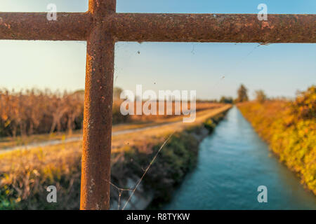 Brücke über einem bewässerungskanal der Lomellina bei Sonnenuntergang Stockfoto